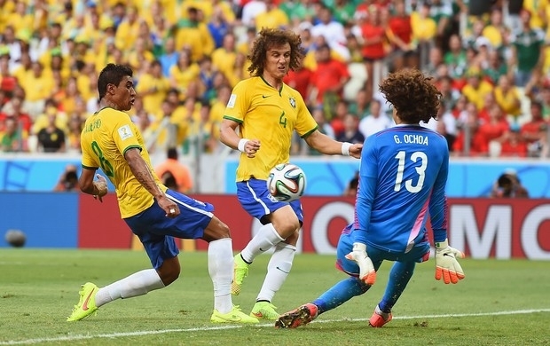 Com os braos junto ao corpo, Ochoa sai do gol e salva concluso de Paulinho