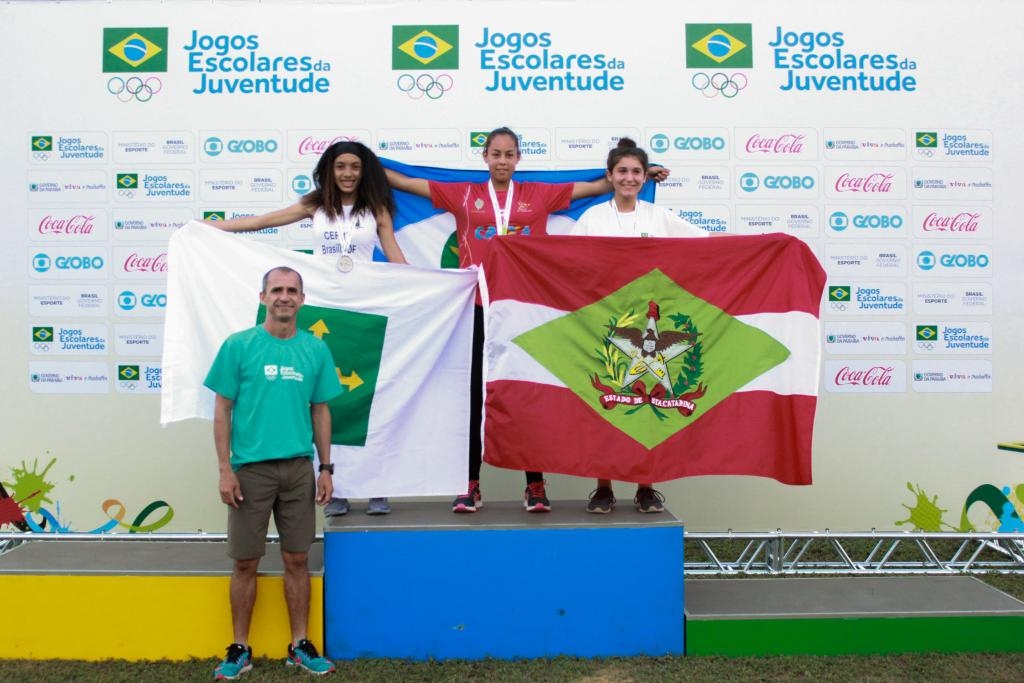 Lissandra, ao centro, sobe ao pdio para receber a medalha de ouro no salto em distncia - Foto por: COB